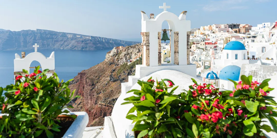 coast view in greece with blue roof houses