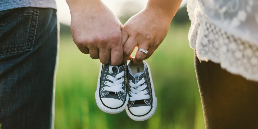 couple holding hands with little shoes