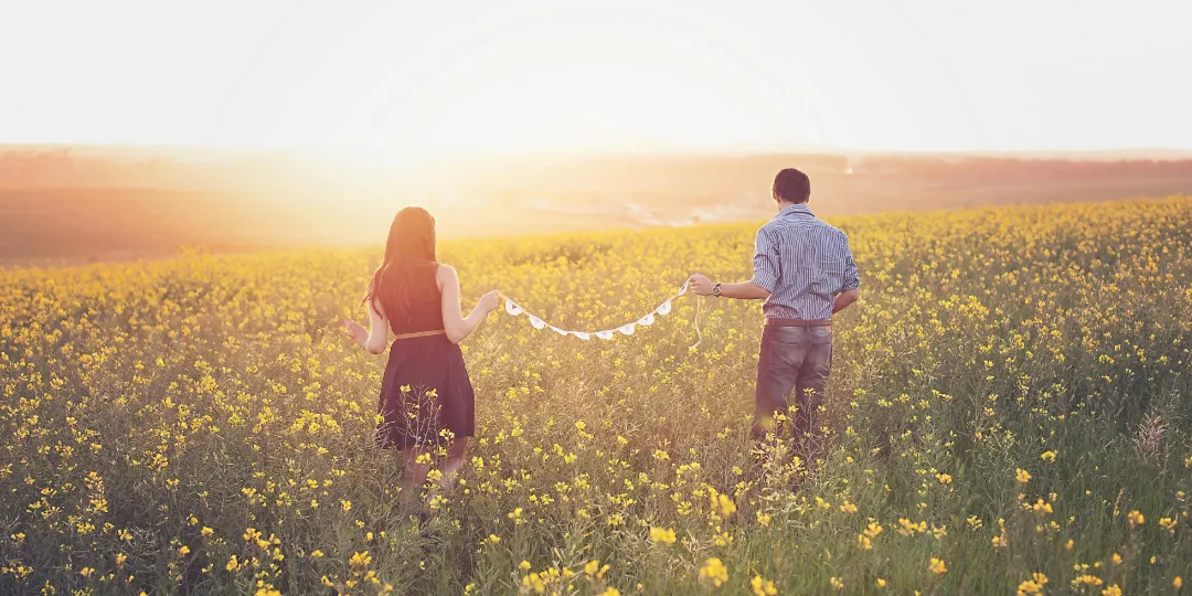 couple walking together trough meadow