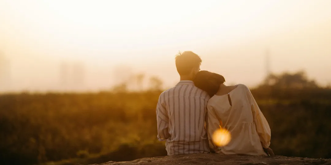 couple watching the sunset over a meadow