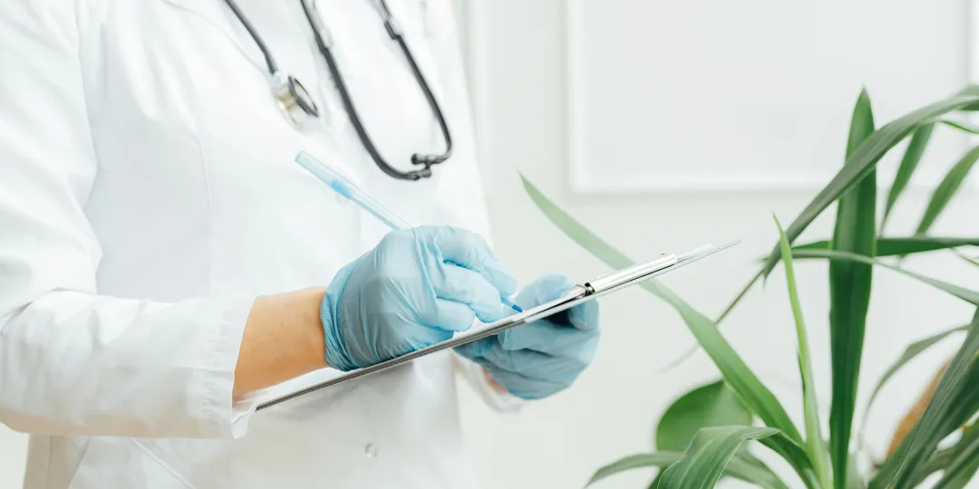 doctor writing on clipboard