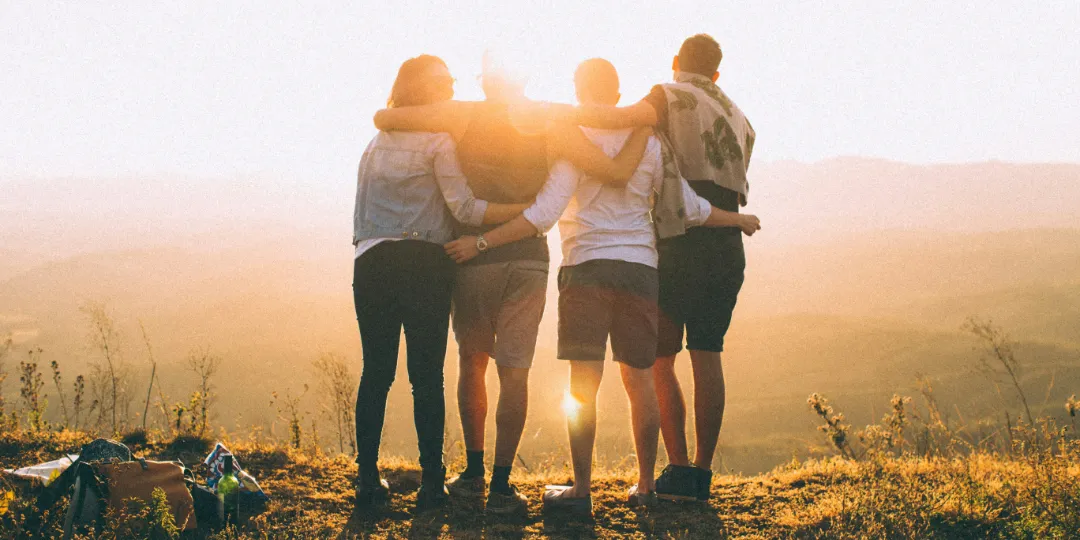 group of friends hugging on mountain