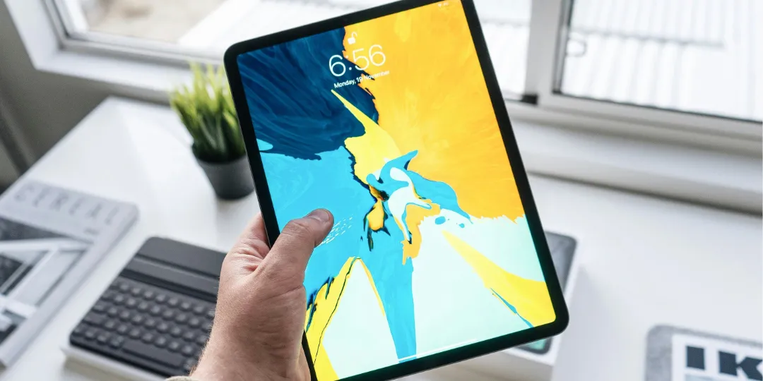 hand holding an ipad with colorful background