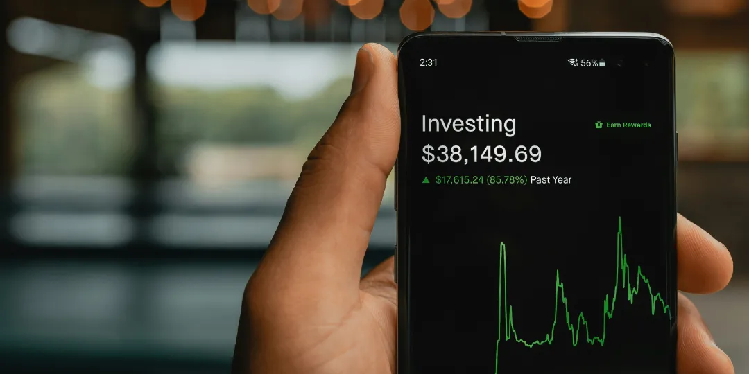 hand holding phone with investing app