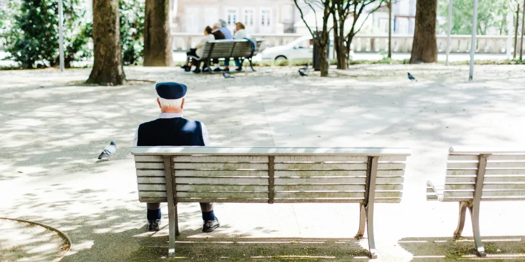 lonely old man sitting on a bench