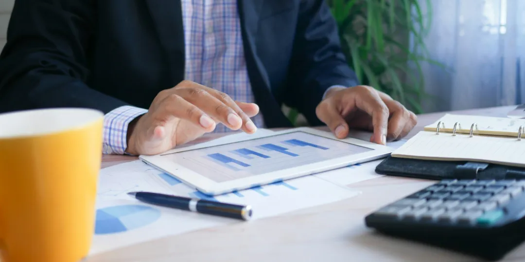 man looking at charts on an ipad