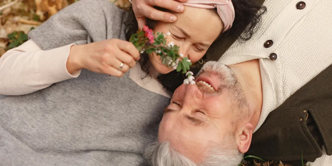 older couple laying on the ground smiling