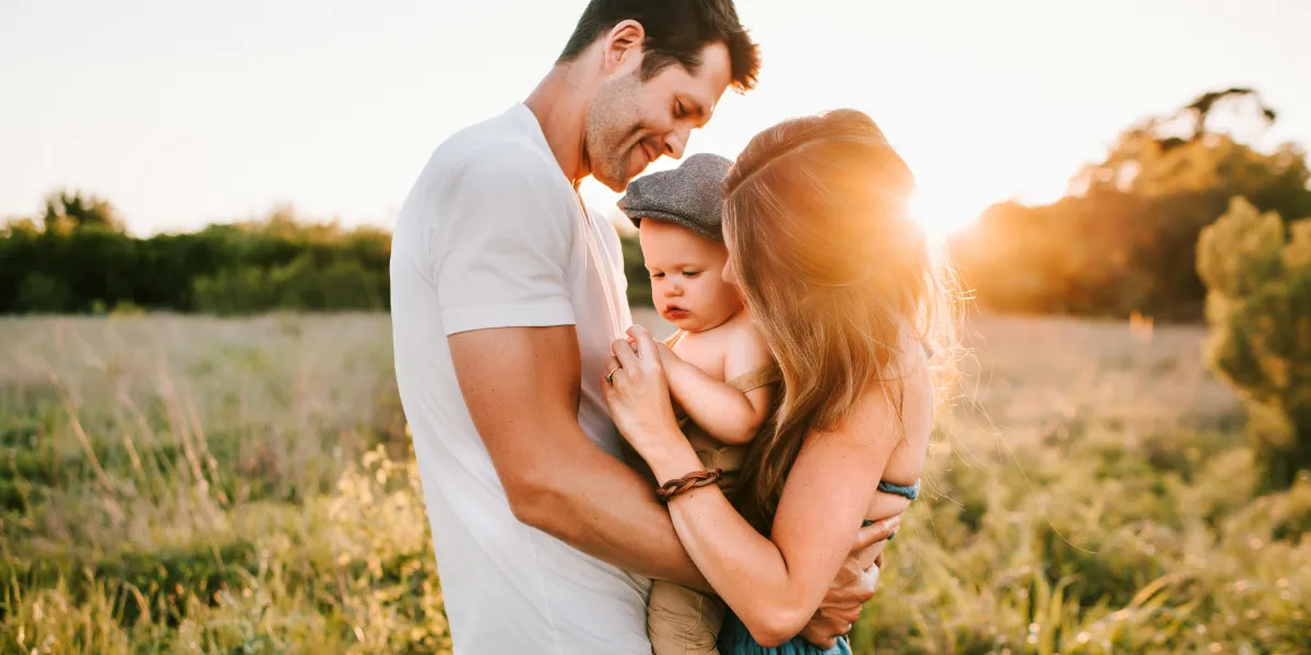 parents hugging their toddler