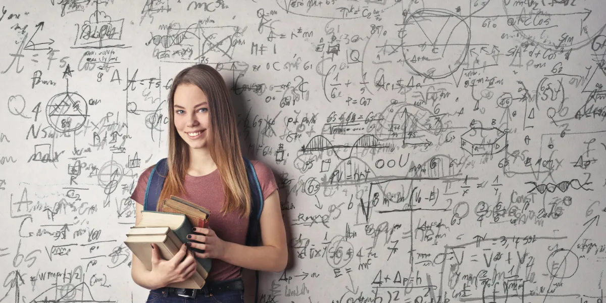 student standing in front of white board with formulas