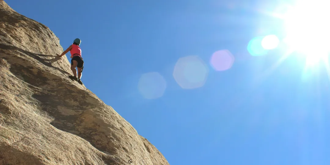 woman climbing up a mountain