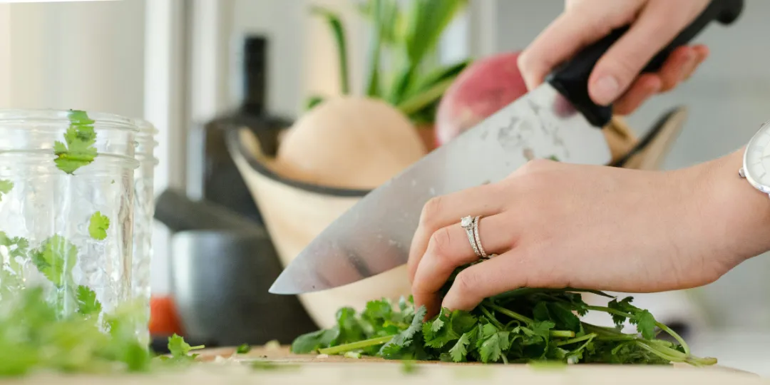 woman cutting vegetables on wooden tray