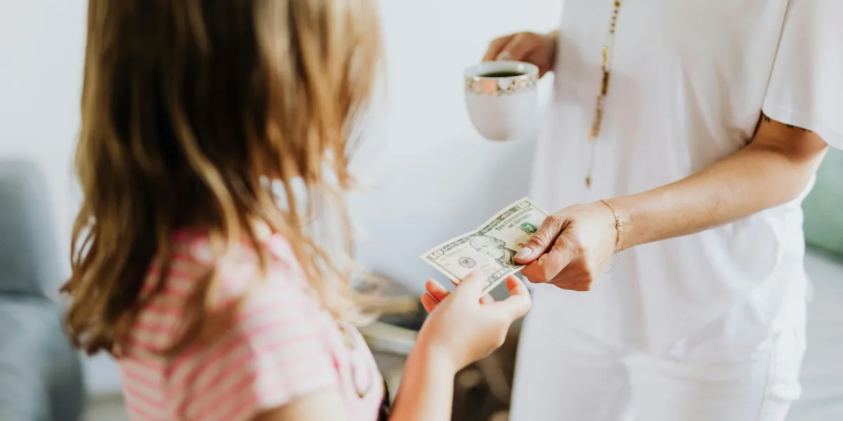 woman giving money to a child