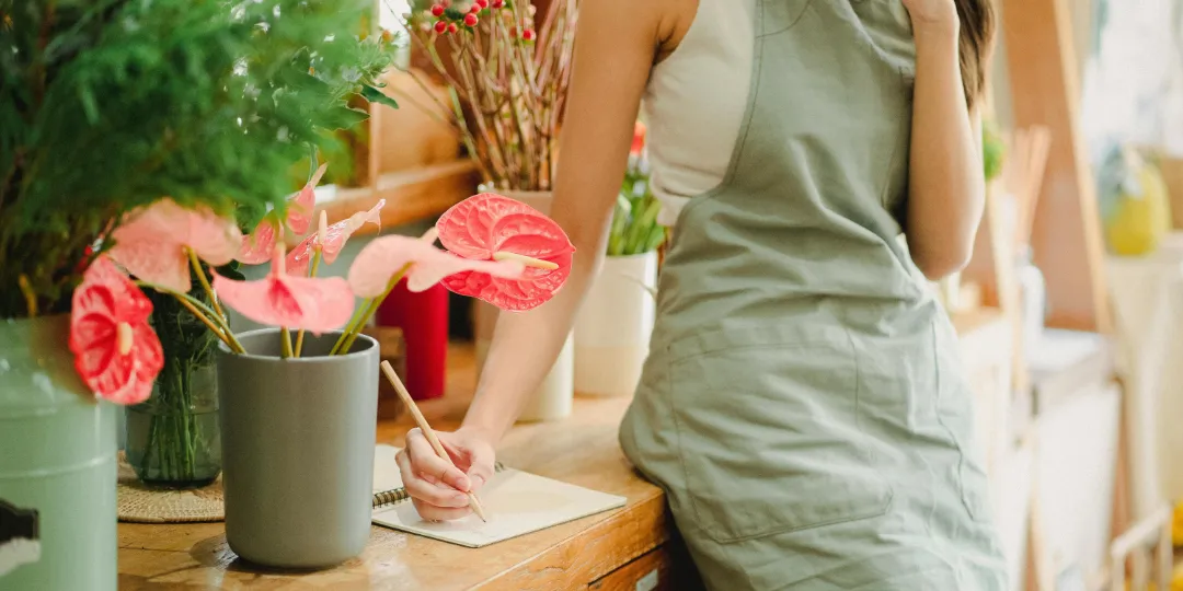 woman in flowershop taking notes