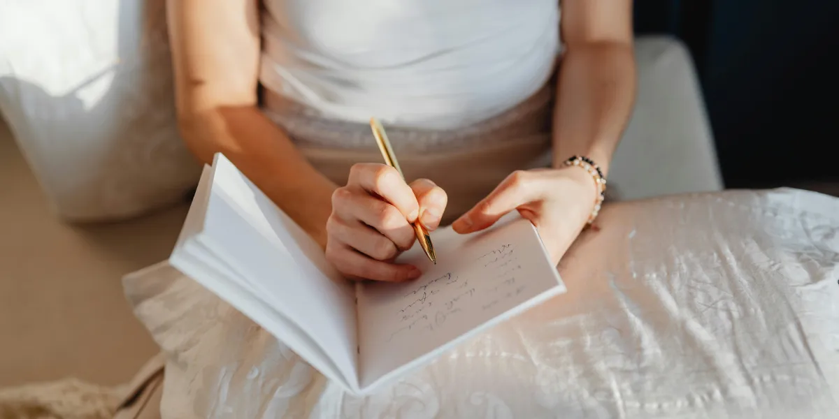 woman journaling while sitting in bed