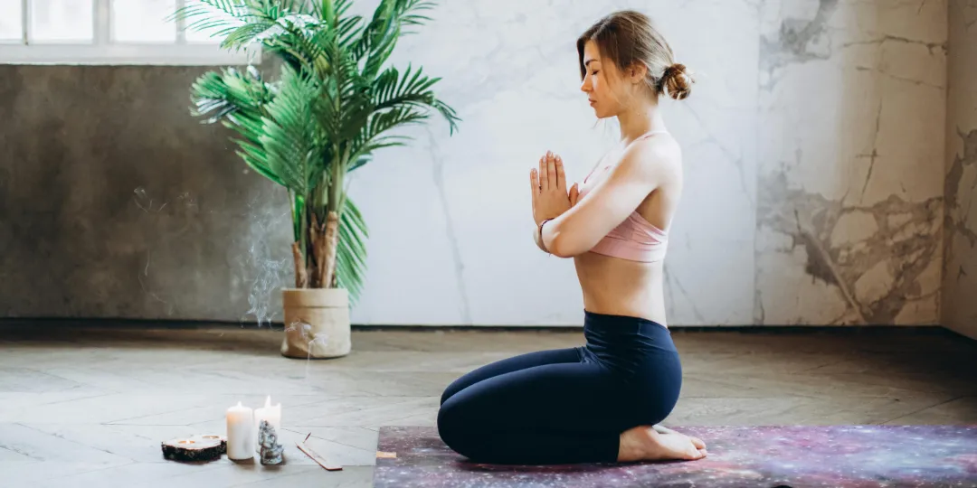 woman kneeling on the floor meditating