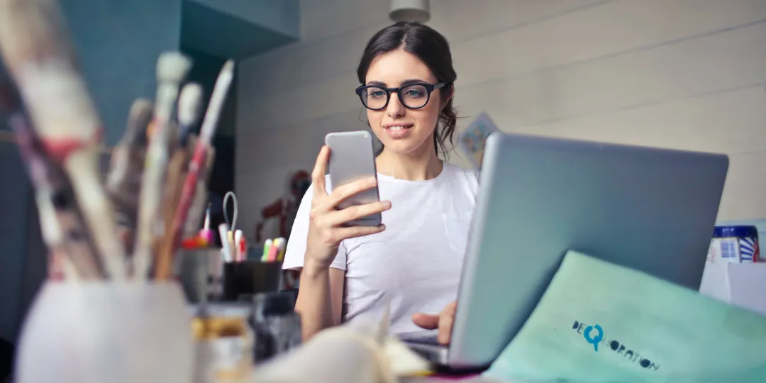 woman on phone with laptop