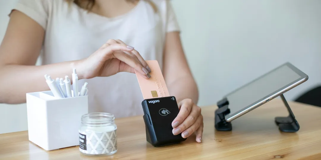 woman sliding credit card in reading device