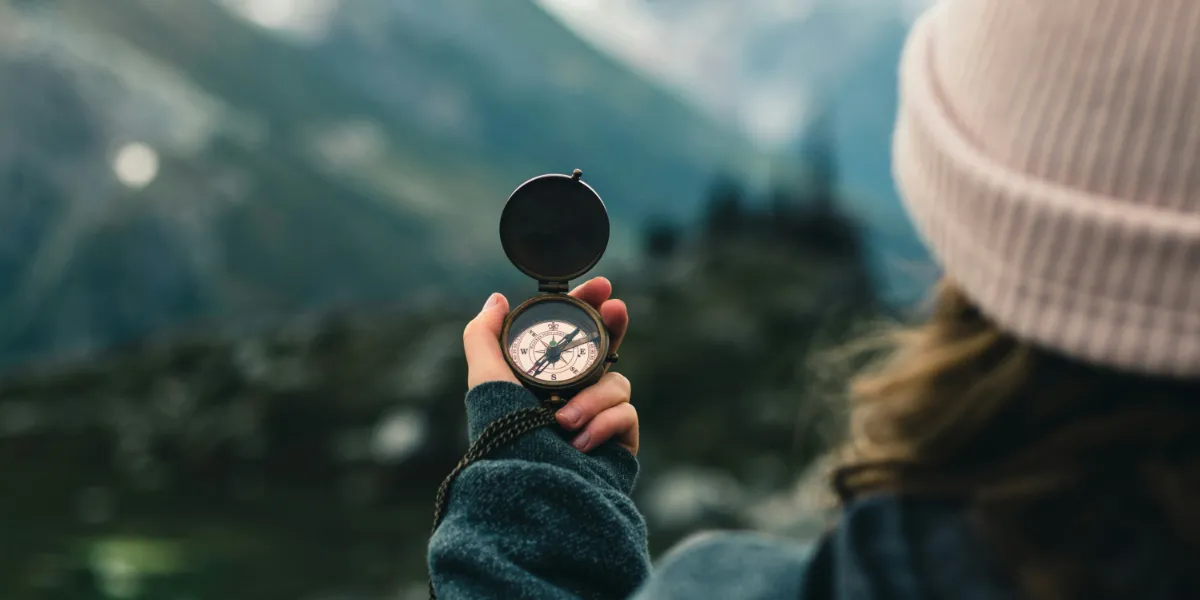 young woman holding compass